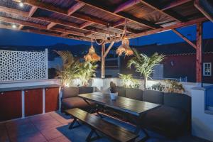 a patio with a wooden table and couch at Casa Blanca Tenerife in Playa de San Juan