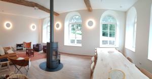 a living room with a table and a fireplace at Domaine St Roch in Couvin