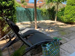 a black lawn chair sitting in a yard at Private Garden in Novamar 5 in Puerto Marino