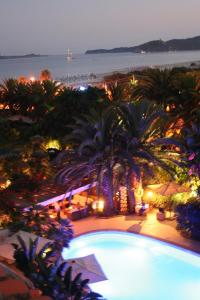 a view of a swimming pool at night at Hotel Simius Playa in Villasimius