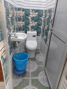 małą łazienkę z toaletą i umywalką w obiekcie Hotel Rajput w mieście Bahādrābād