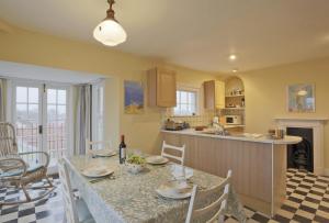 a kitchen and dining room with a table and chairs at 10a East Cliff in Southwold