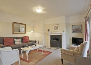 a living room with a couch and a fireplace at 10a East Cliff in Southwold