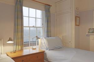 a bedroom with a bed and a window at 10a East Cliff in Southwold