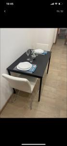een zwarte tafel met twee witte borden en een stoel bij Appartamento stazione centrale in Palermo