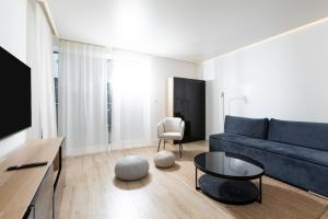 een woonkamer met een blauwe bank en een tafel bij Resort Apartamenty Klifowa Rewal 92 in Rewal