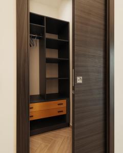 a closet with a wooden door in a room at B&B Mirò Luxury aeroporto capodichino Napoli in Naples