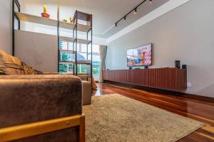 a living room with a couch and a flat screen tv at Serra Loft Premium in Teresópolis