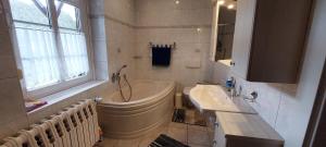 a white bathroom with a tub and a sink at Ferienwohnung Auf der Höhe in Drüsedau