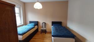 a bedroom with two beds and a chair and a window at Ferienwohnung Auf der Höhe in Drüsedau