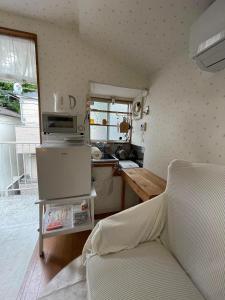 a small kitchen with a couch in a room at Kyodo's small room cottu - Vacation STAY 14595 in Tokyo