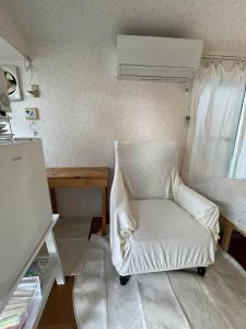 Una silla blanca en una habitación con cama en Kyodo's small room cottu - Vacation STAY 14595, en Tokio