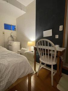 a bedroom with a bed and a desk and a chair at Kyodo's small room cottu - Vacation STAY 14595 in Tokyo