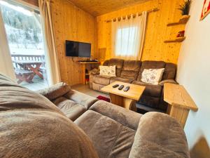 a living room with a couch and a table at Kreischberg 14b - Chalet direkt am Skilift in Sankt Lorenzen ob Murau