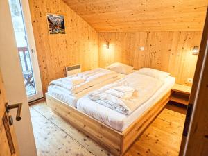 a bedroom with a large bed in a wooden room at Kreischberg 14b - Chalet direkt am Skilift in Sankt Lorenzen ob Murau