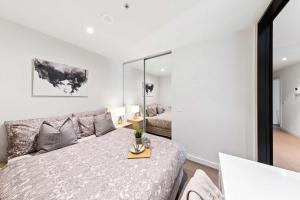 a white bedroom with a bed and a couch at Rb4 801-20 Coro in Melbourne