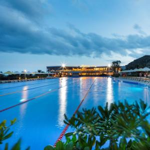 una piscina notturna con un edificio sullo sfondo di Villa Bien - Resort Oceanami - Long Hai - 3 & 4 Phòng Ngủ a Long Hai