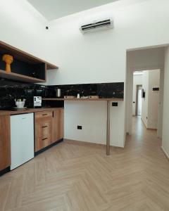 una cucina con pareti bianche e pavimenti in legno di B&B Mirò Luxury aeroporto capodichino Napoli a Napoli