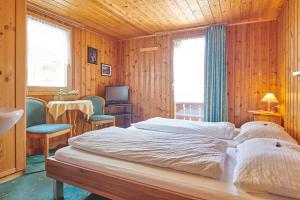 Schlafzimmer mit einem Bett, einem Tisch und Stühlen in der Unterkunft Hotel Weisshorn in Zermatt