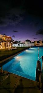 a large blue swimming pool at night at The Beach in La Paloma