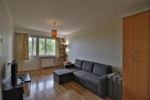 een woonkamer met een bank en een televisie bij Song Festival apartment, 5-10 min from bus/airport in Tallinn