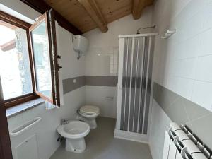 a white bathroom with a toilet and a window at Il Borgo dei Normanni in Colliano +40 photos