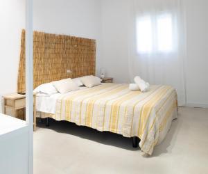 ein Schlafzimmer mit einem Bett mit einer gelben und weißen Decke in der Unterkunft Apartamento Maria Benlliure in Bellreguart