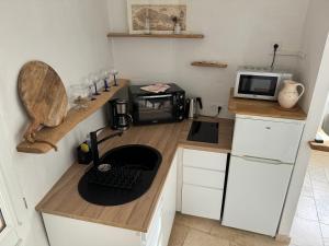 een kleine keuken met een aanrecht met een magnetron bij Studio 3 pers coeur de village Bormes les Mimosas in Bormes-les-Mimosas