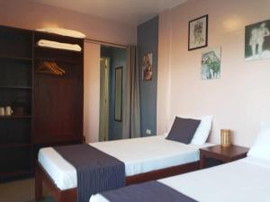 um quarto de hotel com duas camas e uma mesa em The Lazy Tiki em Buenavista