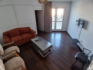 ein Wohnzimmer mit einem Sofa und einem Tisch in der Unterkunft Sunny Inn Les berges du lac 1 in Tunis