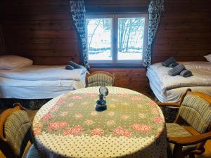 a room with a table and two beds and a window at Niedźwiedziówka in Jaworki