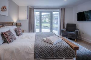 ein Schlafzimmer mit einem Bett, einem Stuhl und einem Fenster in der Unterkunft Suite 7 - Sleeping Giant Hotel - Pen Y Cae Inn in Brecon