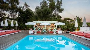 a pool with chairs and tables next to a bar at Hôtel La Tartane Saint-Tropez in Saint-Tropez +63 photos