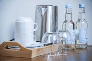 a wooden tray with bottles and glasses on a table at Suite 15 - Sleeping Giant Hotel - Pen Y Cae Inn in Brecon