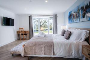 a white bedroom with a large bed and a window at Suite 9 - Sleeping Giant Hotel - Pen Y Cae Inn in Brecon