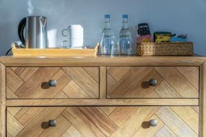 a wooden dresser with bottles on top of it at Suite 9 - Sleeping Giant Hotel - Pen Y Cae Inn in Brecon