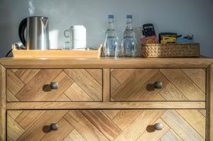 a wooden dresser with bottles on top of it at Suite 10 - Sleeping Giant Hotel - Pen Y Cae Inn in Brecon