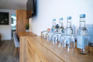 una fila di bicchieri da vino seduti su un tavolo di legno di Suite 8 - Sleeping Giant Hotel - Pen Y Cae Inn a Brecon