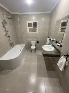 a bathroom with a tub and a toilet and a sink at New Lotus Hotel in Cairo