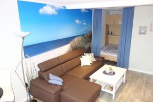 una sala de estar con sofá y una pintura de la playa en "Ostseeblick" L-7-6, en Heiligenhafen