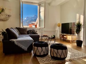 ein Wohnzimmer mit einem Sofa und 2 Hockern in der Unterkunft EVA o Wellnessoasis o Montainview o Pizzaoven o in Ingenbohl