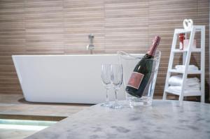 a bottle of champagne and two glasses on a counter at Suite 5 - Sleeping Giant Hotel - Pen Y Cae Inn in Brecon