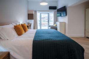 a bedroom with a large bed with orange pillows at Suite 5 - Sleeping Giant Hotel - Pen Y Cae Inn in Brecon