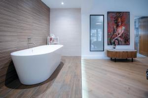uma casa de banho com uma banheira branca e uma mesa em Suite 5 - Sleeping Giant Hotel - Pen Y Cae Inn em Brecon