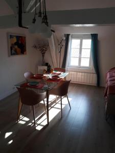 d'une salle à manger avec une table, des chaises et une fenêtre. dans l'établissement ALEIDA, à La Rochelle