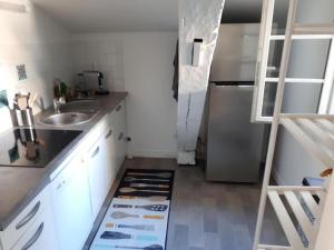 a small kitchen with a sink and a refrigerator at ALEIDA in La Rochelle