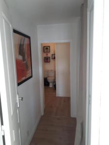 - un couloir avec des toilettes dans une chambre blanche dans l'établissement ALEIDA, à La Rochelle