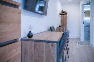 Habitación con mesa de madera y TV en la pared. en Suite 6 - Sleeping Giant Hotel - Pen Y Cae Inn en Brecon