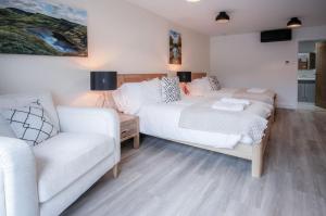 a bedroom with a bed and a couch at Suite 3 - Sleeping Giant Hotel - Pen Y Cae Inn in Brecon