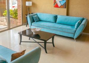 uma sala de estar com um sofá azul e uma mesa de centro em Yene hue em Puerto Madryn